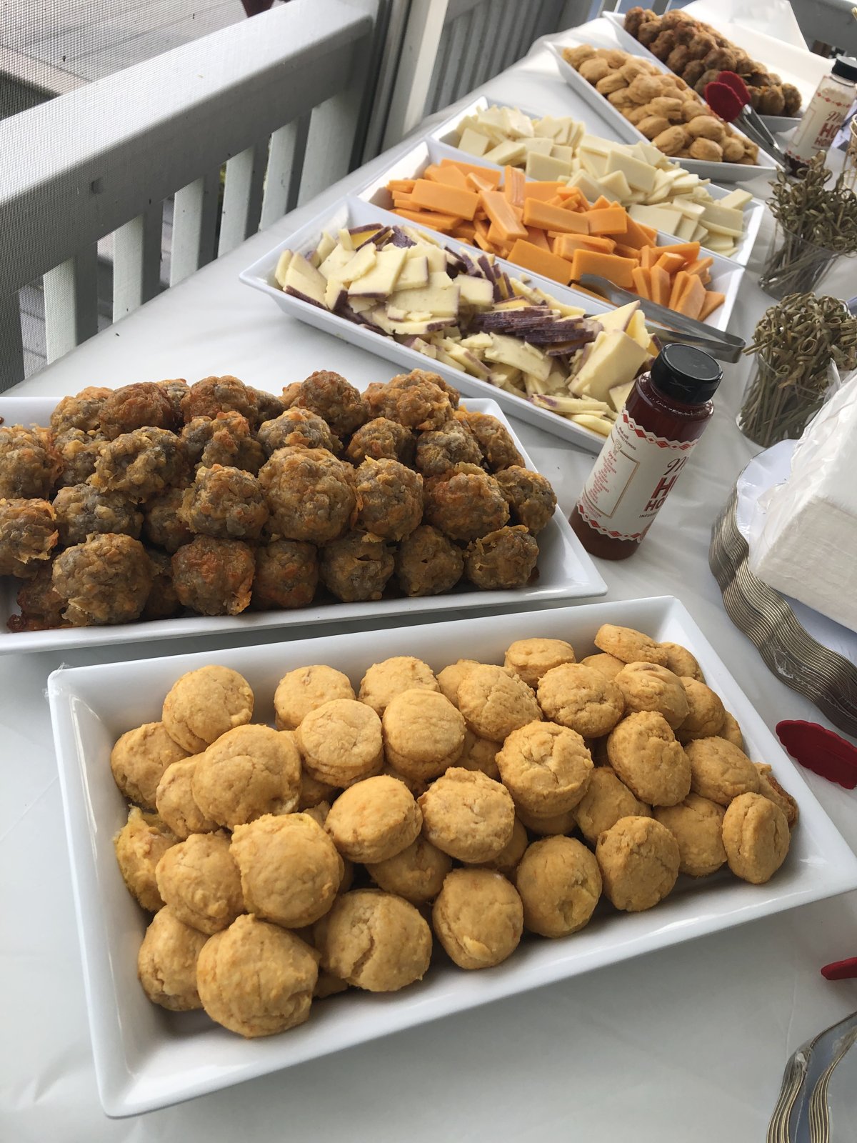 Appetizer spread of sausage balls, mini sweet potato biscuits and cheese trays