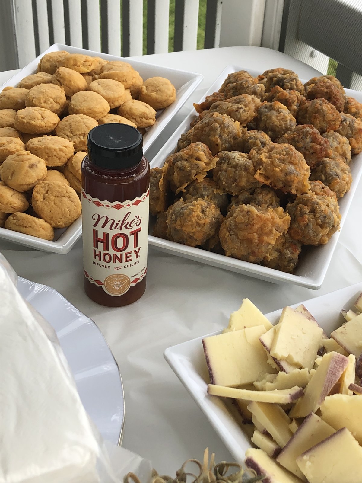 Close-up of sausage balls and sweet potato biscuits served with hot honey