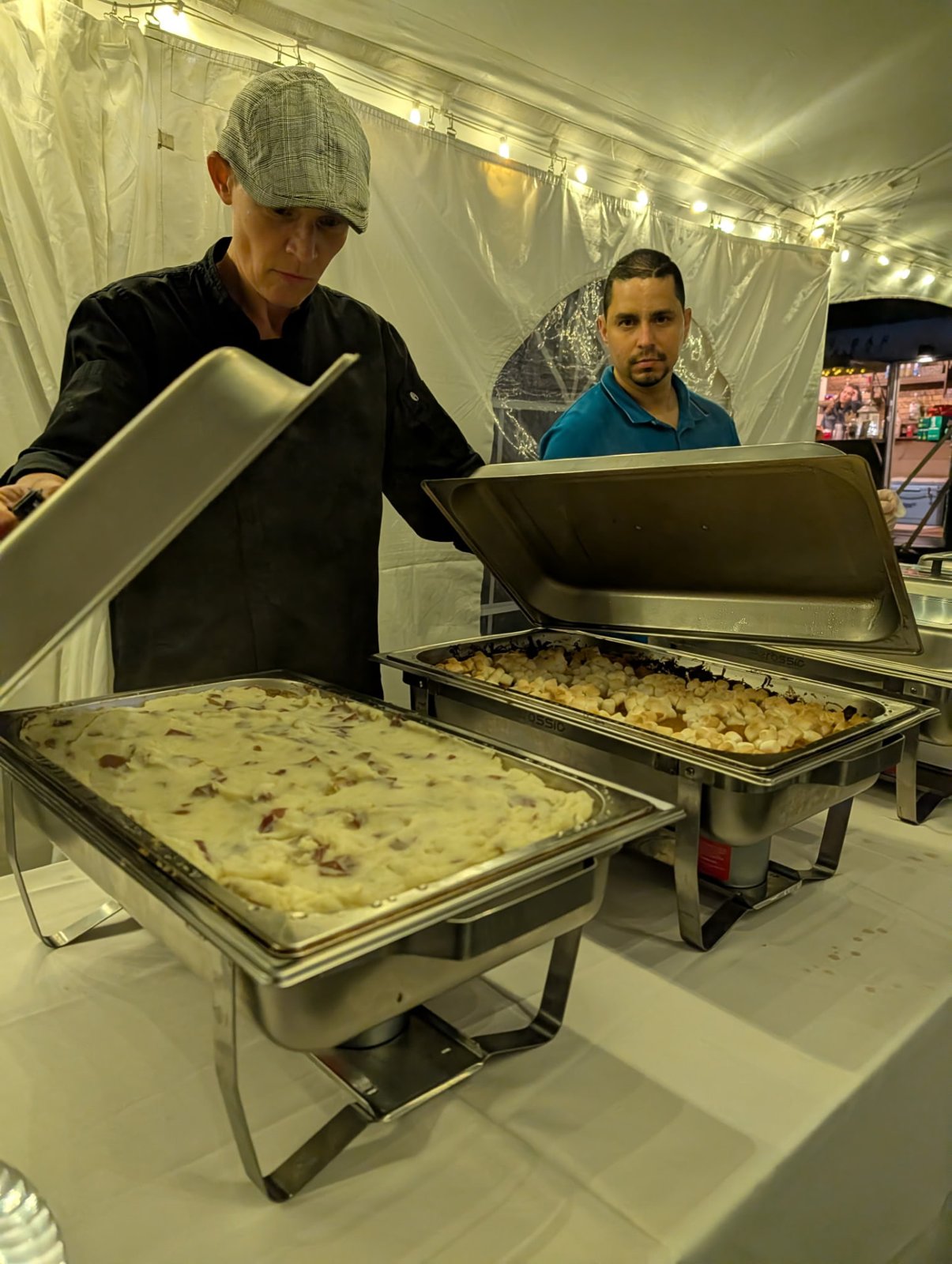 Chef serving loaded mashed potatoes and sweet potato casserole from chafing dishes at a catered event