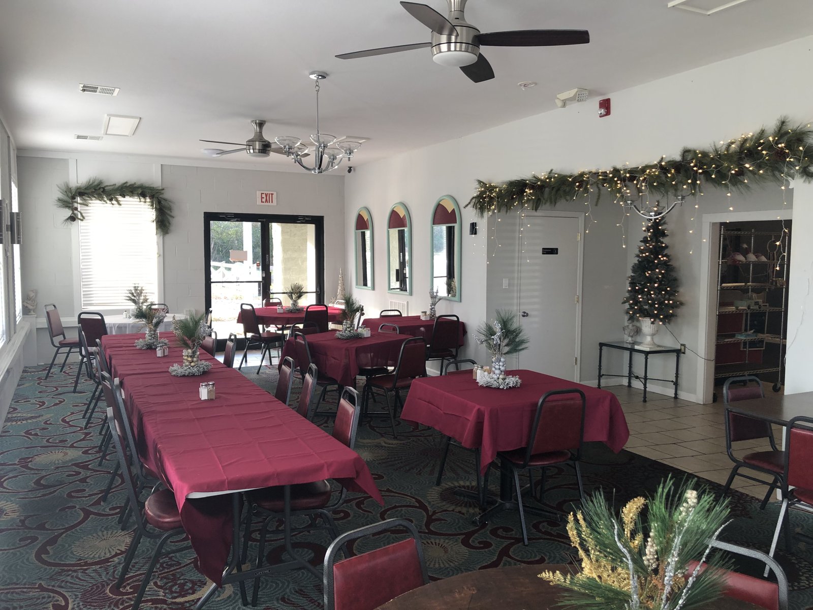 Private dining room set with red linens and Christmas decorations for a holiday party